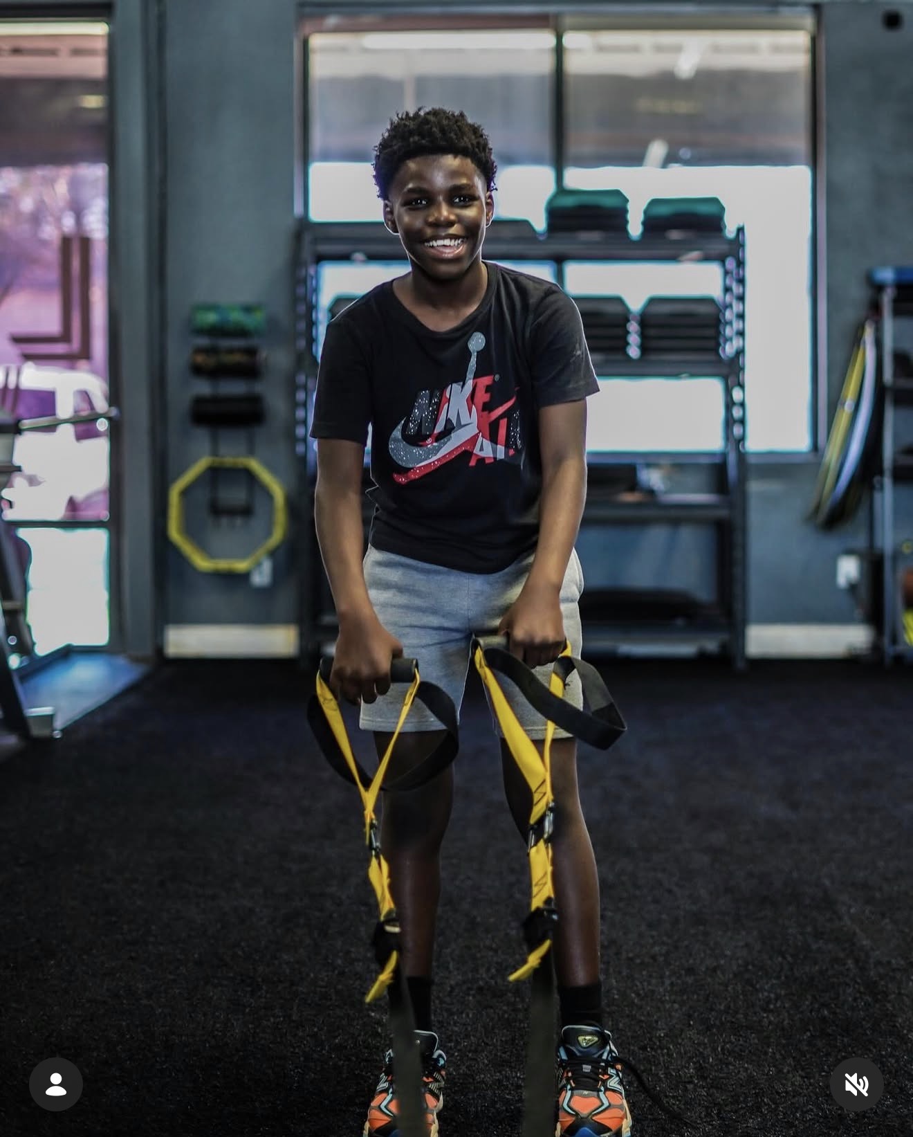 Smiling young athlete holding suspension trainer handles