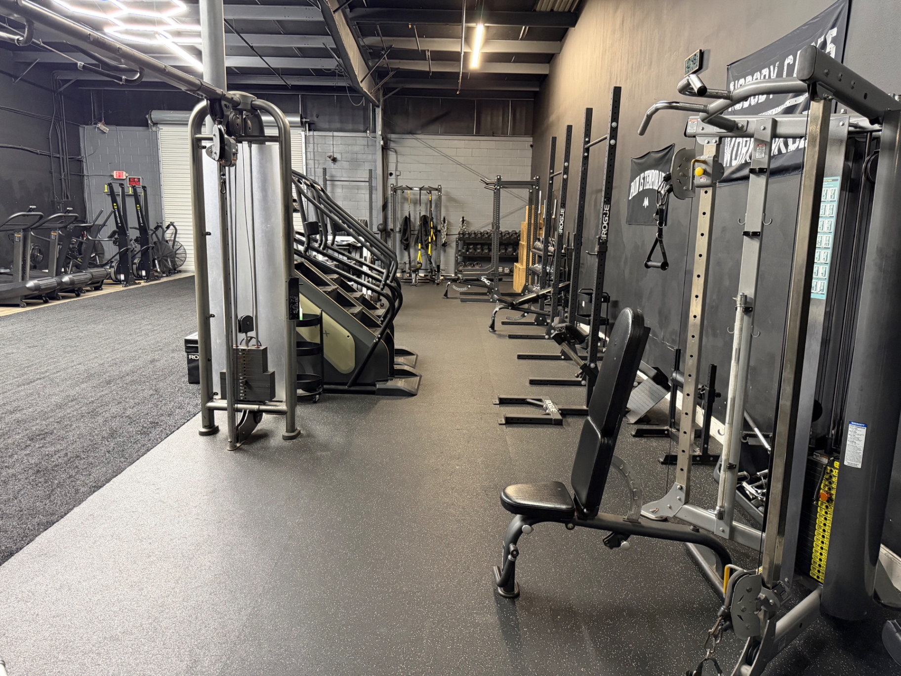 Interior of the Look Who's Fit training facility with racks and cardio equipment