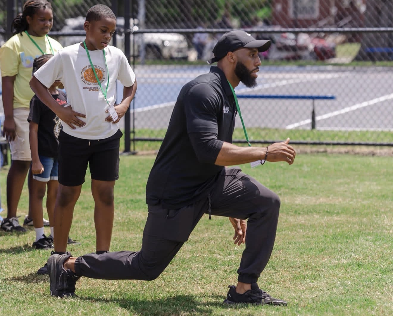 Founder demonstrating a lunge for kids during an outdoor training session